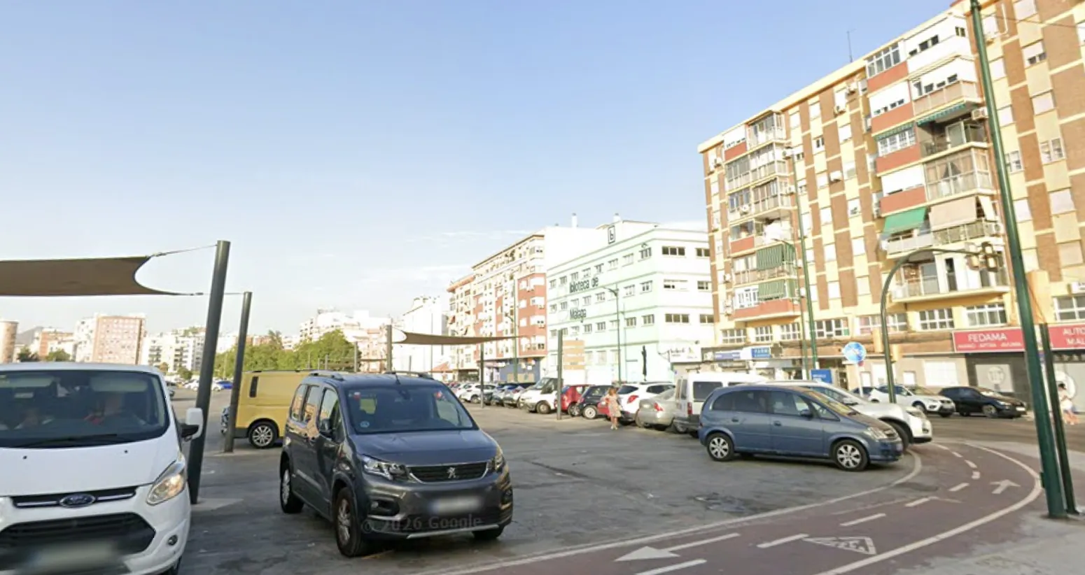 Explanada del Mercadillo de Huelin con coches aparcados, junto a MASVAPE Av. de la Paloma