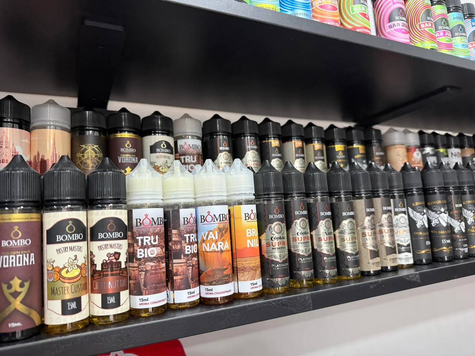 Estantería de MASVAPE en Málaga con botellas de líquido colocadas en filas por sabores