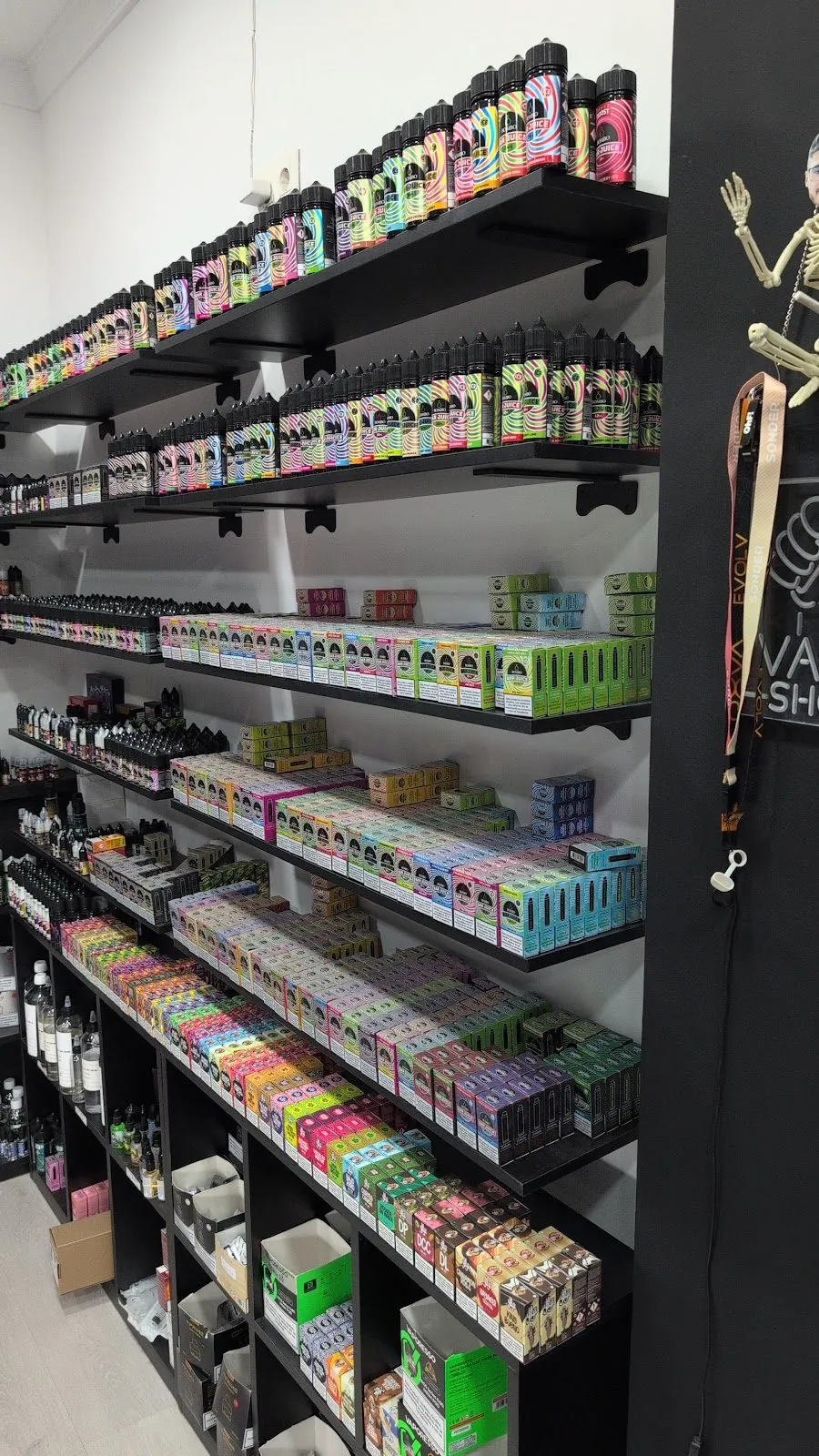 Pasillo de la tienda MASVAPE en Málaga con las estanterías llenas de líquidos y cajas