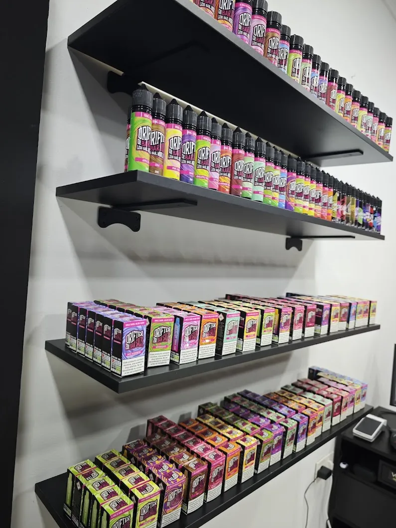 Estanterías de MASVAPE con líquidos alineados y cajas en las baldas inferiores